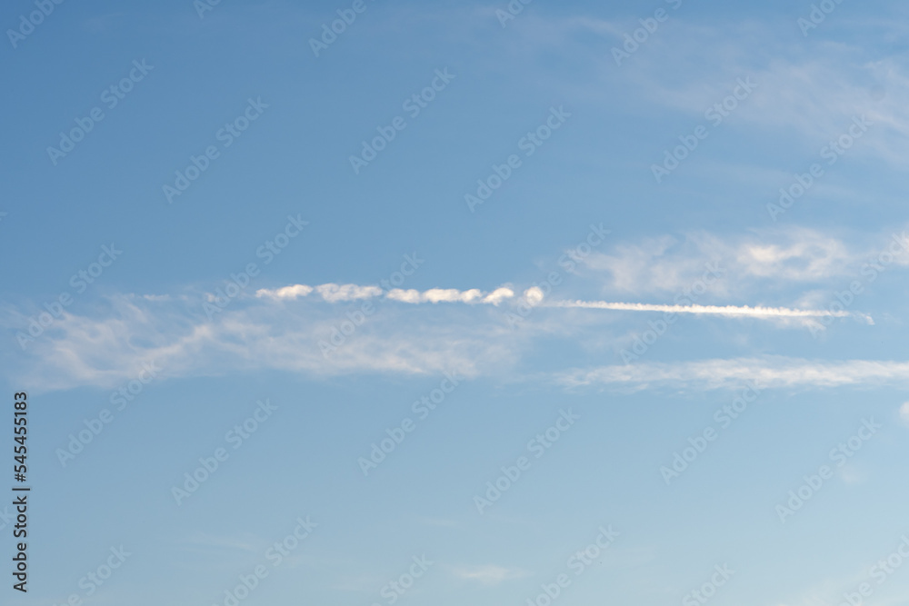A condensation trail from an aeroplane or rocket against a blue sky. Concept: missile overflying in the sky, war in Ukraine.