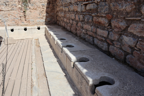 Ancient public Toilet bathroom seats on Ephesus made of rocks, bricks, granite and marble photo