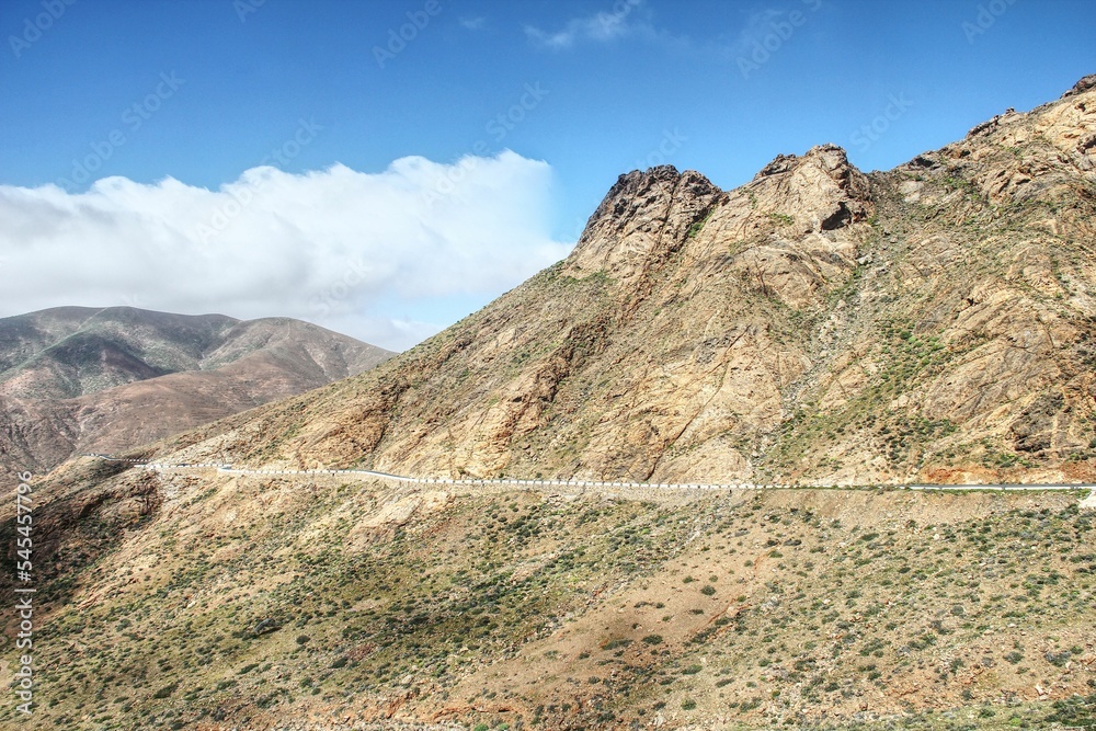 Narrow road along a mountain pass through the desert-like landscape of Fuertventura, Spain