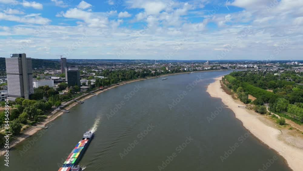 Aerial view of the river Rhine, with skyscrapers and woods at its banks, passing a cargo ship Aerial view of the river Rhine, with skyscrapers and woods at its banks, passing a cargo ship