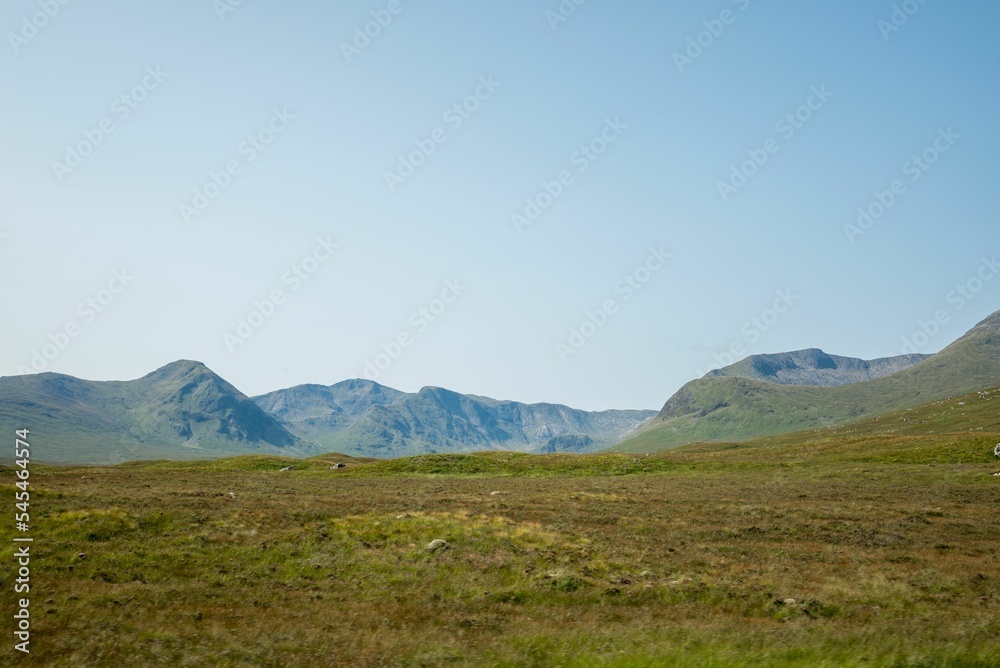 Clear blue sky over the grass-covered field and hills on a sunny day Clear blue sky over the grass-covered field and hills on a sunny day