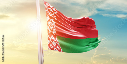 Waving Flag of Belarus in Blue Sky. The symbol of the state on wavy cotton fabric.