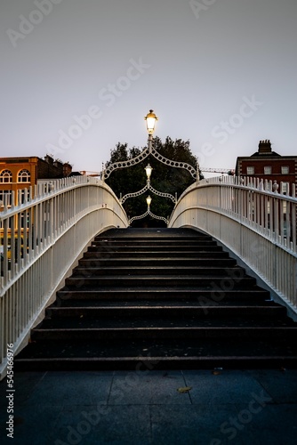 Photography Vertical shot of the Ha'penny Bridge with lit lanterns at dusk