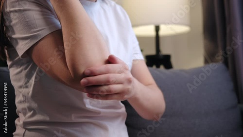 Wallpaper Mural Close up of unhealthy young caucasian woman touches elbow in morning and massages sitting on grey couch at home, warming up injured hand after trauma. Arthritis of joints pain in elbow concept Torontodigital.ca