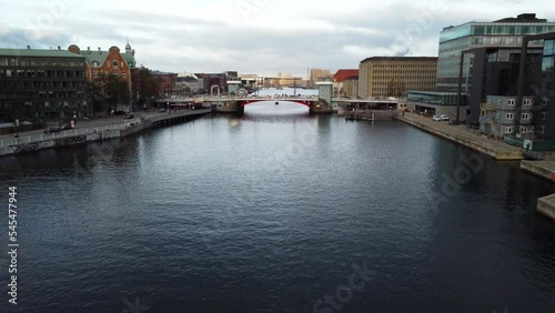 Drone shot over a canal near water towards bridge in Copenhagen