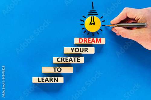 Create your dream symbol. Concept words Learn to create your dream on wooden blocks. Businessman hand. Beautiful blue table blue background. Business learn to create your dream concept. Copy space.