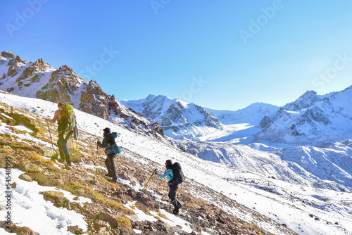 A group of hikers with a guide make their final steps towards lake Manshuk-Mametovoj, located near Talgar. Late October days, though sunny, meet us with snow even on the warm sides of the mountains.
