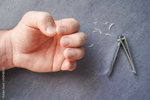 Cut the nails on the hands with nail clippers. Men's manicure. Male hand close up.