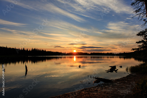 The sun rises over an alpine lake in the mountains of Colorado