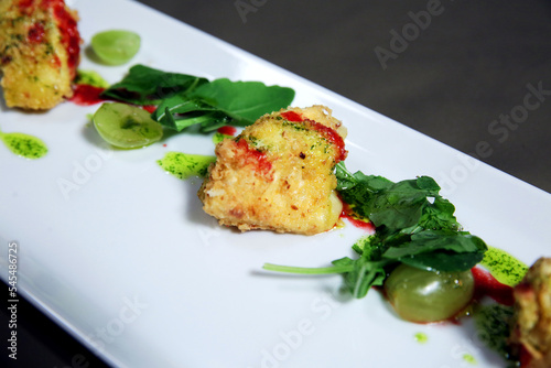 A plate with snacks made of grilled ingredients with sauce and vegetables