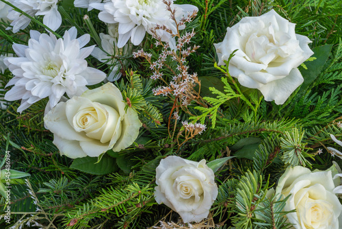 Flower arrangement for All Saints Day. Bouquet of white chrysanths mixed with white roses and fir tree branches. Grave decoration