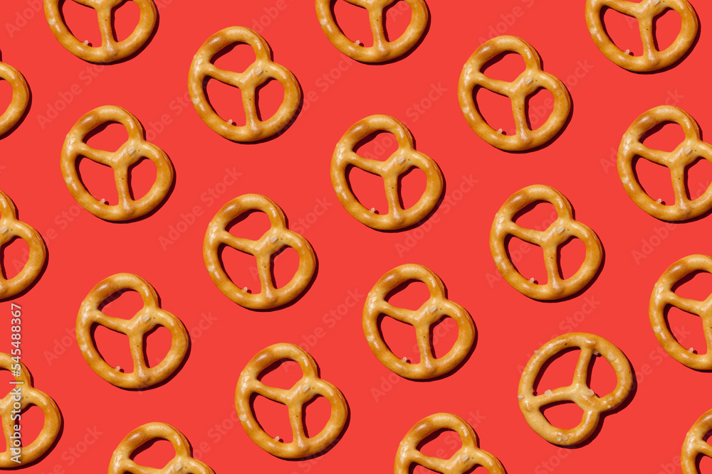 pattern with salty traditional pretzels on red background pattern with salty traditional pretzels on red background