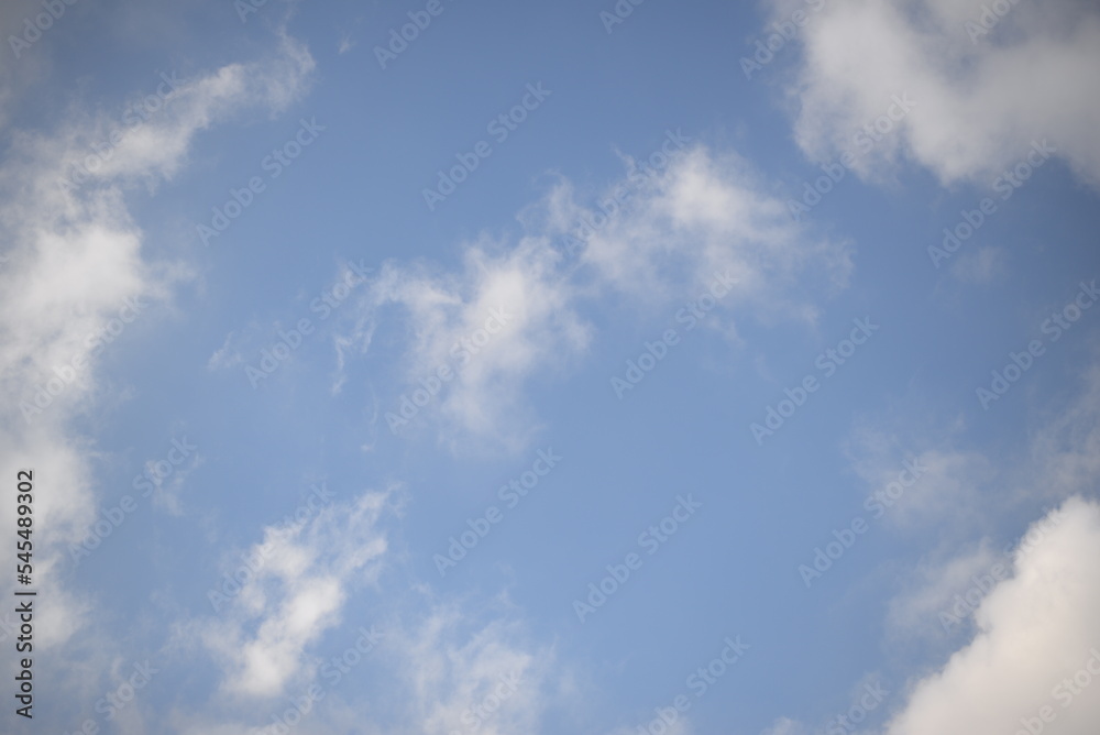 rays of the sun through cirrus clouds against a blue sky, white rainy clouds against a blue sky illuminated by the rays of the sun rays of the sun through cirrus clouds against a blue sky, white rainy clouds against a blue sky illuminated by the rays of the sun