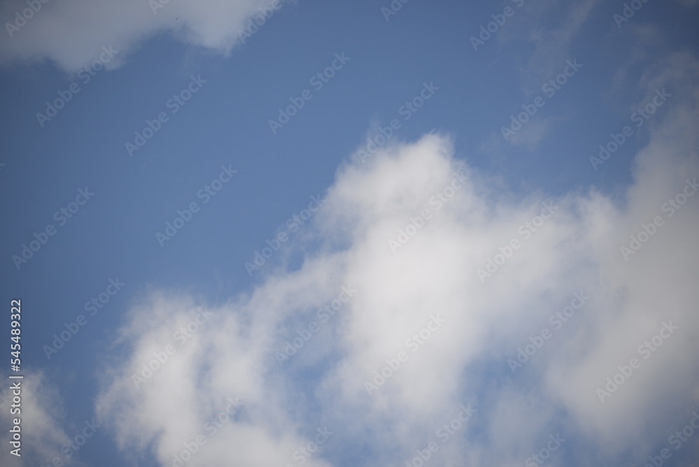 rays of the sun through cirrus clouds against a blue sky, white rainy clouds against a blue sky illuminated by the rays of the sun rays of the sun through cirrus clouds against a blue sky, white rainy clouds against a blue sky illuminated by the rays of the sun