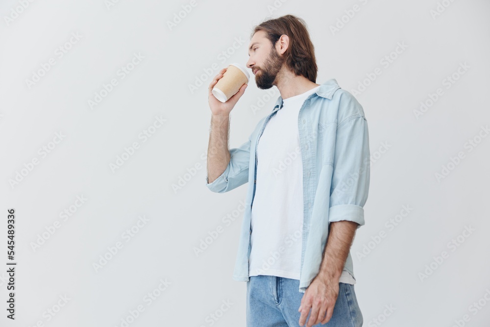 Freelance Millennial man with beard drinking coffee from a crab cup in stylish hipster clothes on a white background