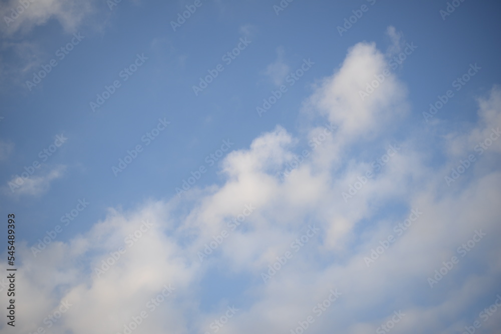 rays of the sun through cirrus clouds against a blue sky, white rainy clouds against a blue sky illuminated by the rays of the sun rays of the sun through cirrus clouds against a blue sky, white rainy clouds against a blue sky illuminated by the rays of the sun