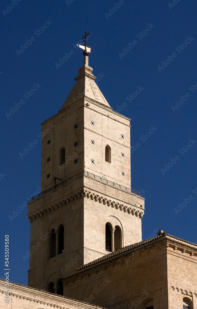 MATERA, ITALY - OCTOBER 17, 2022:  The tower of Matera Cathedral isolated against a blue sky