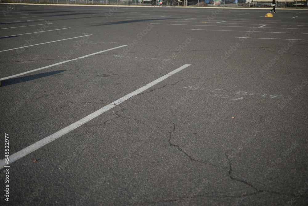 
background road markings white stripes on the asphalt road, parking spaces separated by white lines, symmetrical abstract lines on gray asphalt