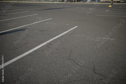  background road markings white stripes on the asphalt road, parking spaces separated by white lines, symmetrical abstract lines on gray asphalt © Анна Климчук