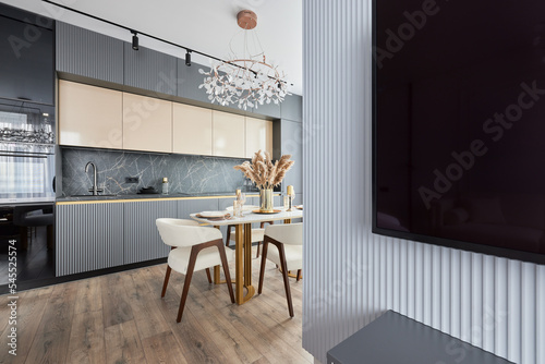 Modern interior of studio apartment in gray and  white colors and tones. White furniture and door. Expensive and luxury design