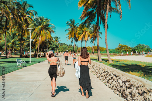 Фотография couple walking on the beach woman ocean drive miami