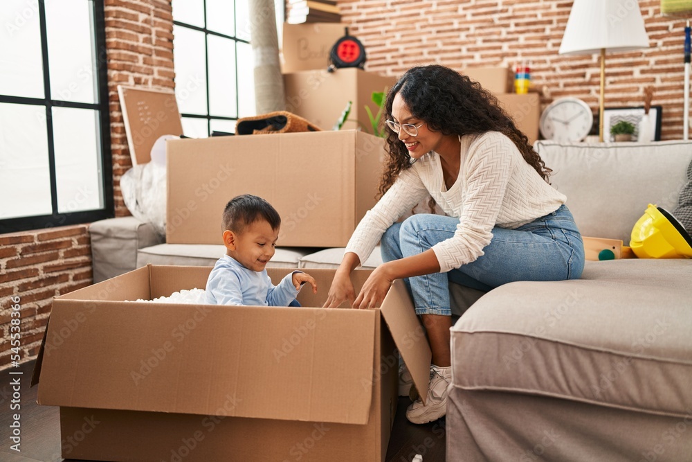 Mother and son playing with cardboard as a car at new home Mother and son playing with cardboard as a car at new home