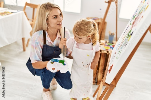 Mother and daughter smiling confident drawing at art studio