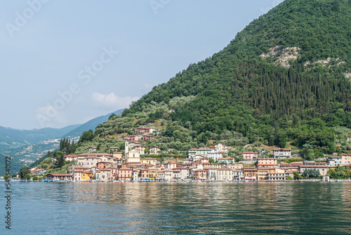 Landscape of the lakeside of Peshiera Maraglio in Monte Isola with beautiful colored houses reflecting in the water