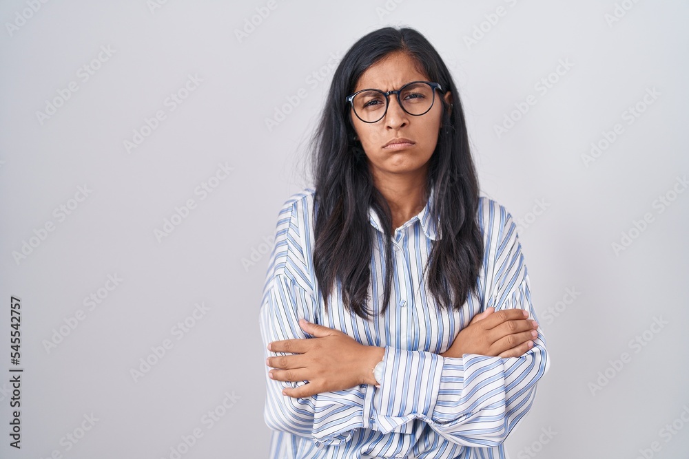 Young hispanic woman wearing glasses skeptic and nervous, disapproving expression on face with crossed arms. negative person. Young hispanic woman wearing glasses skeptic and nervous, disapproving expression on face with crossed arms. negative person.