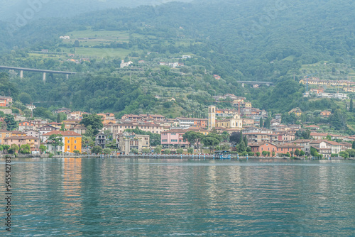 Panorama of the lakeside of Sulzano with colored houses that reflecting in the Lake Iseo