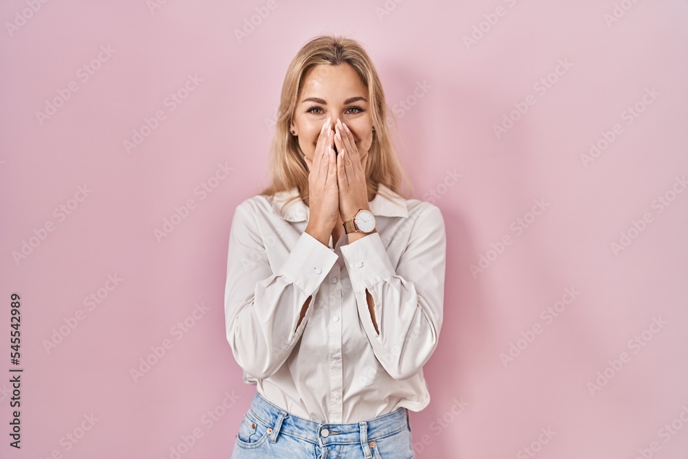 Young caucasian woman wearing casual white shirt over pink background laughing and embarrassed giggle covering mouth with hands, gossip and scandal concept Young caucasian woman wearing casual white shirt over pink background laughing and embarrassed giggle covering mouth with hands, gossip and scandal concept