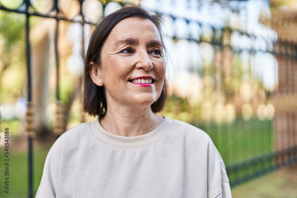 Middle age woman smiling confident standing at park