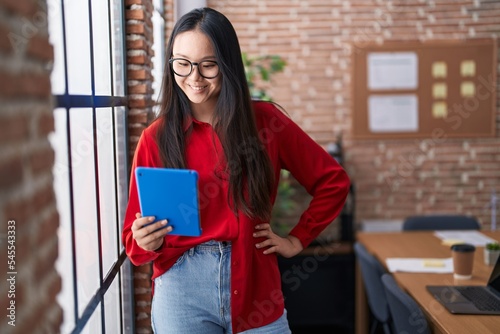 Obraz na plátně Young chinese woman business worker smiling confident using touchpad at office