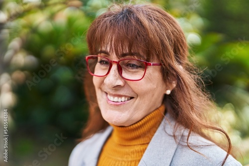 Middle age woman business executive smiling confident at park