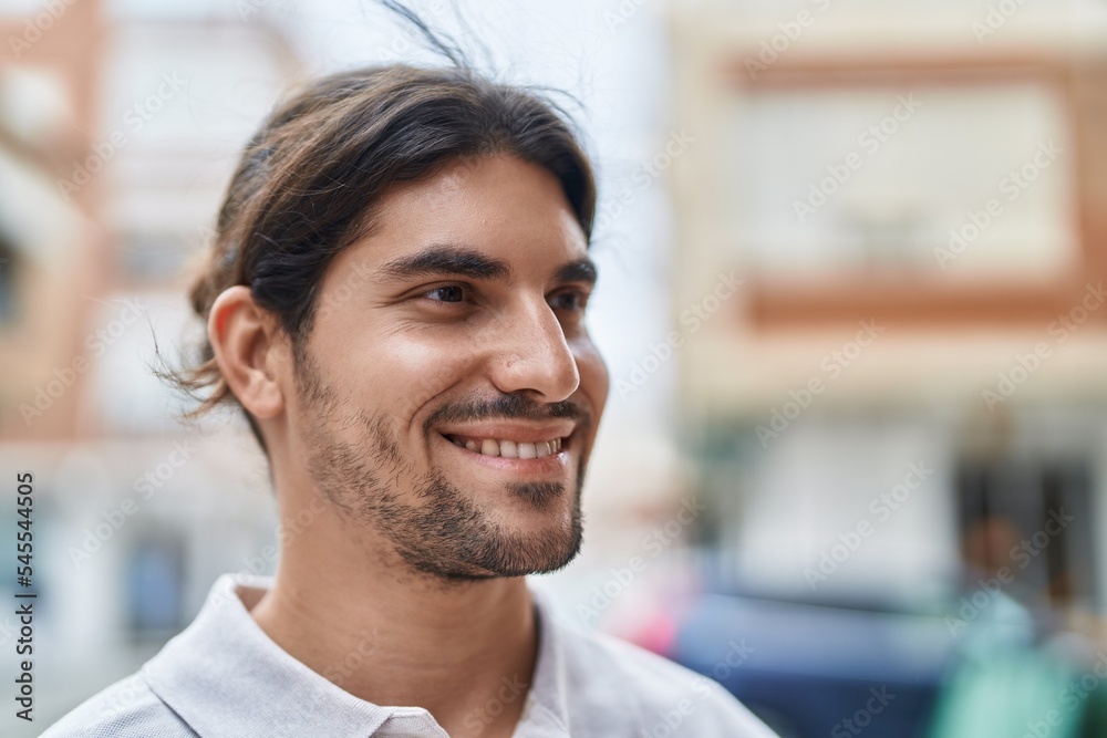 Obraz premium Young hispanic man smiling confident looking to the side at street