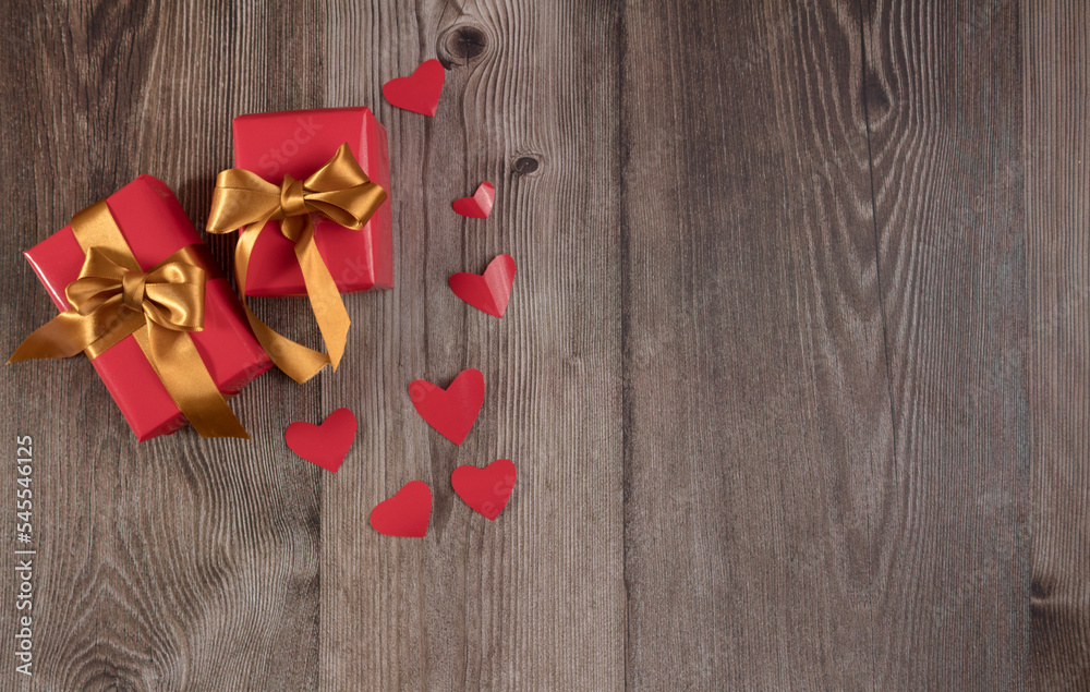 Two gifts and hearts on wooden table