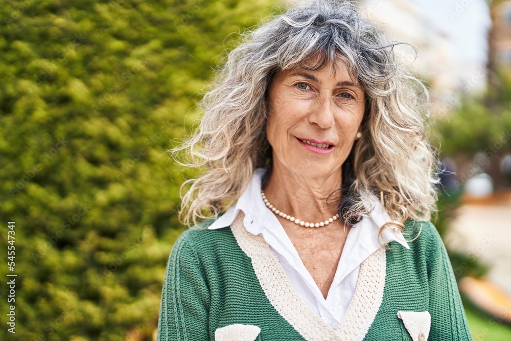 Middle age woman with relaxed expression standing at park Middle age woman with relaxed expression standing at park