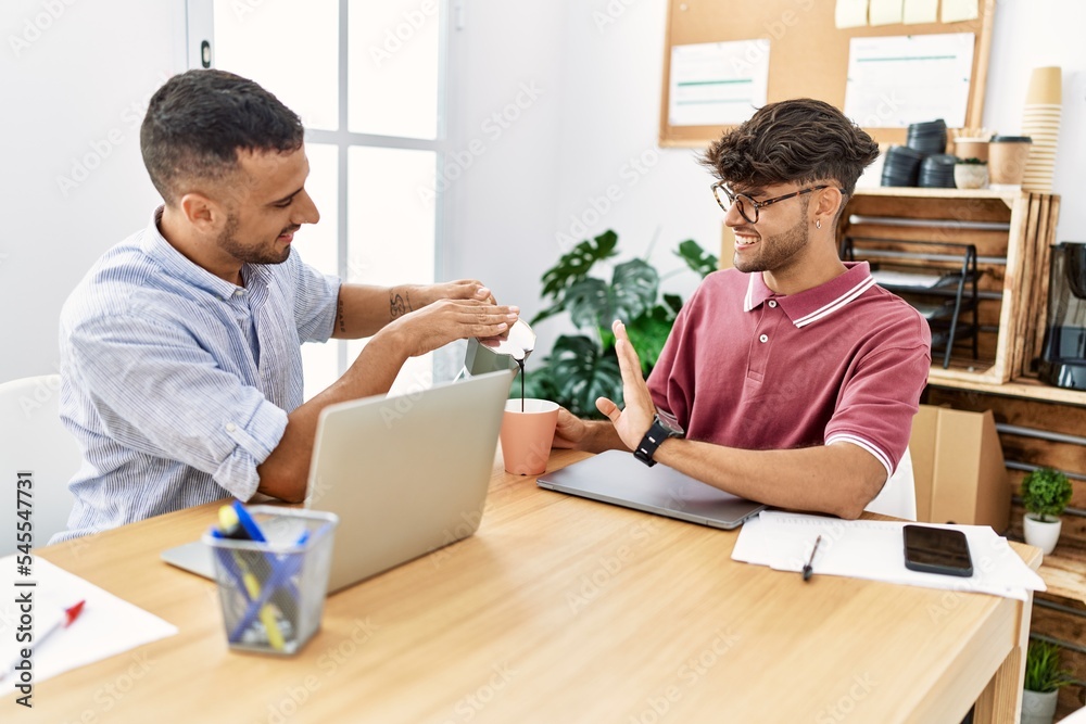 Two business workers smiling happy drinking coffee at the office. Two business workers smiling happy drinking coffee at the office.
