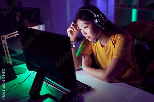 Chinese woman streamer stressed using computer at gaming room
