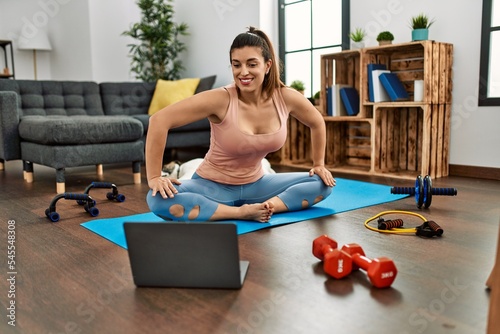 Young woman smiling confident having online stretching class at home