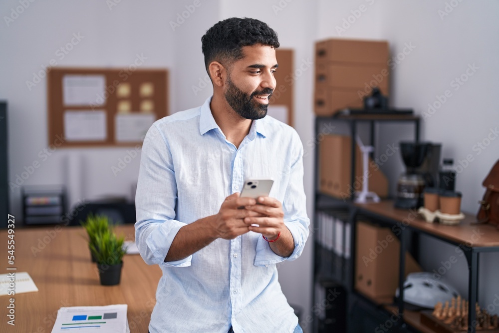 Young arab man business worker smiling confident using smartphone at office