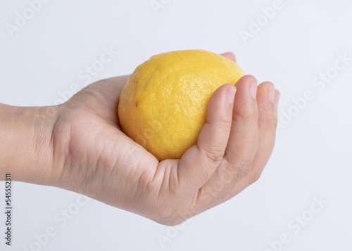 Hand woman holding fresh lemon