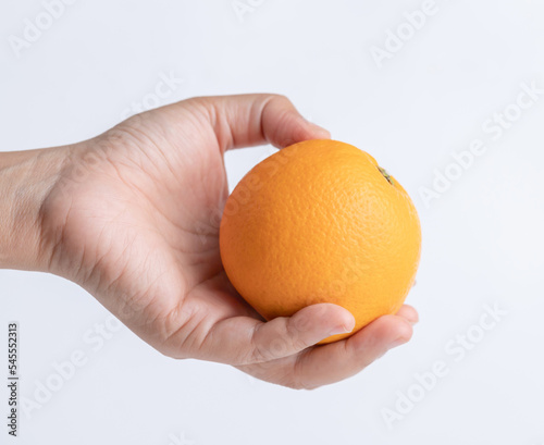hand holding fresh orange on white background