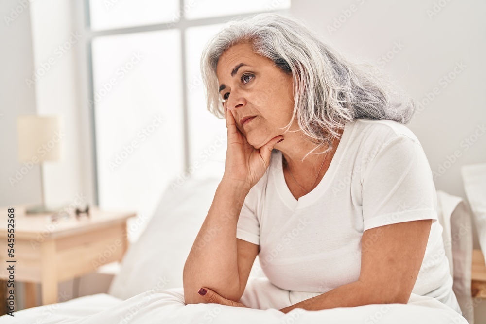 Middle age woman stressed sitting on bed at bedroom Middle age woman stressed sitting on bed at bedroom