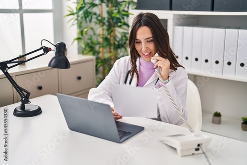 Young hispanic woman wearing doctor uniform having teleconsultation at clinic