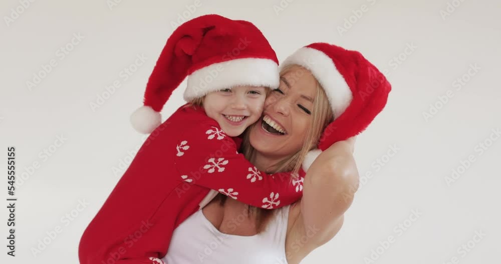 Christmas and New Year, mom and daughter. Mom hugs her daughter gently, studio, white background Christmas and New Year, mom and daughter. Mom hugs her daughter gently, studio, white background