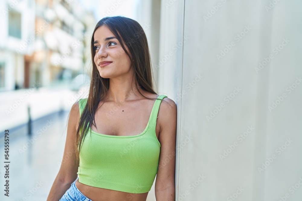 Fototapeta premium Young beautiful hispanic woman smiling confident looking to the side at street