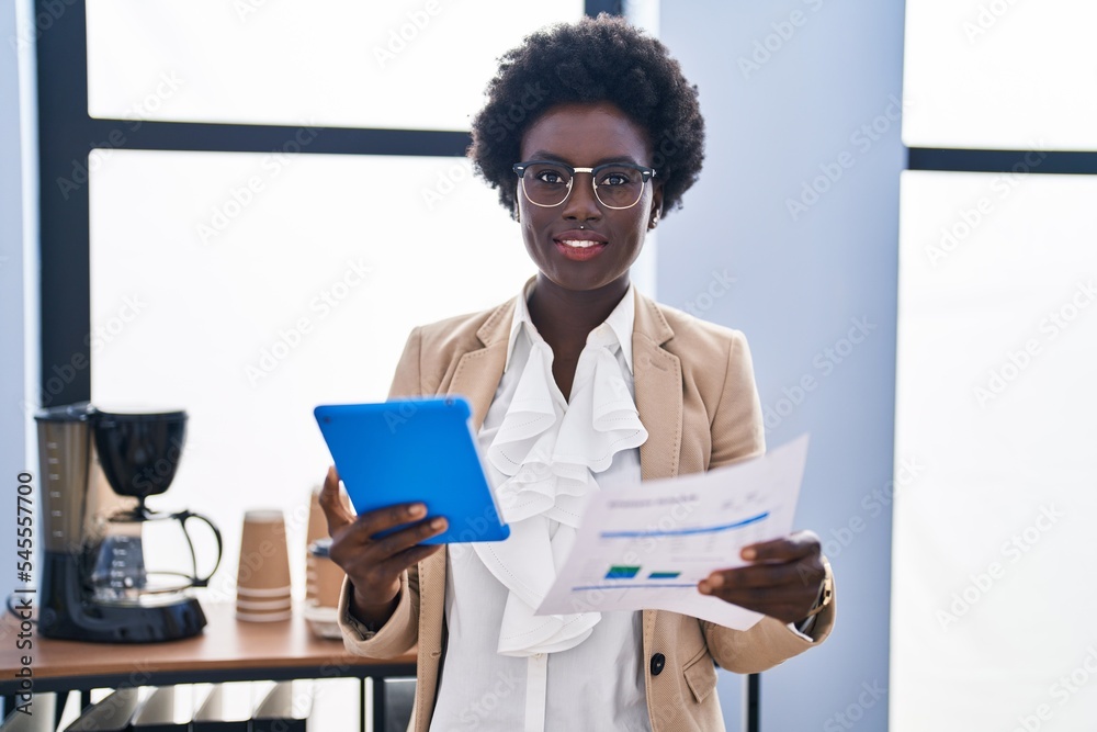 Young african american woman business worker using touchpad reading document at office Young african american woman business worker using touchpad reading document at office