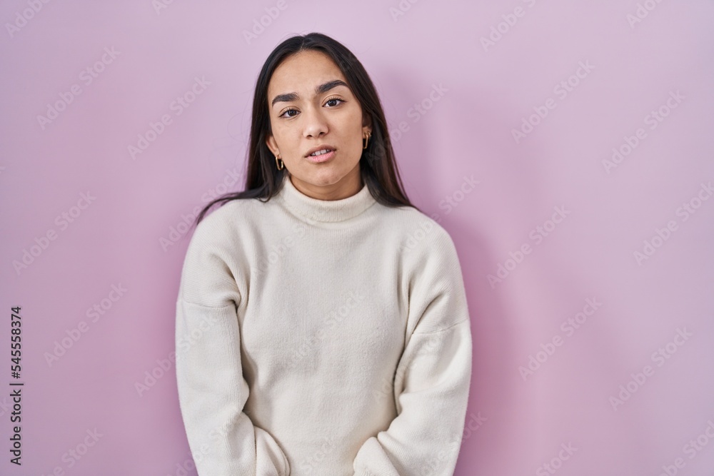 Fototapeta premium Young south asian woman standing over pink background looking sleepy and tired, exhausted for fatigue and hangover, lazy eyes in the morning.