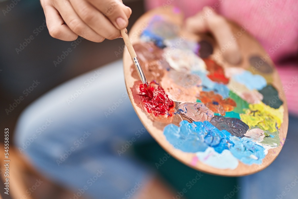 Young hispanic woman mixing color on palette at art studio Young hispanic woman mixing color on palette at art studio